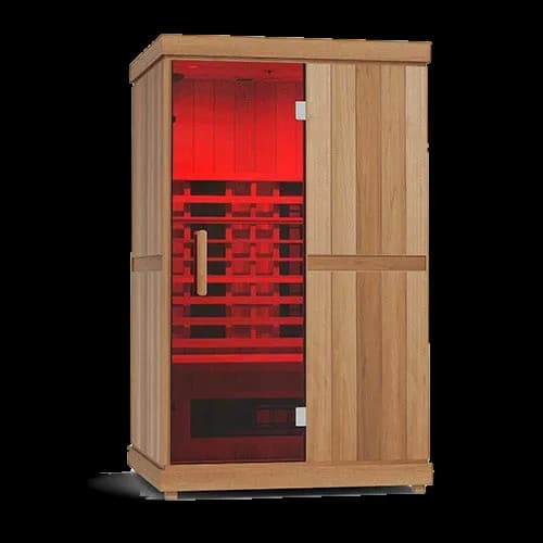Finnmark FD-2 cabin in light wood, glass door on the left glowing red from the infrared panels inside